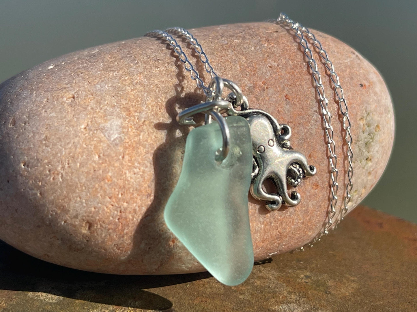 Eco friendly aqua sea glass necklace on a sterling silver chain showcasing a little octopus. Octopus pendant, eco friendly jewellery.
