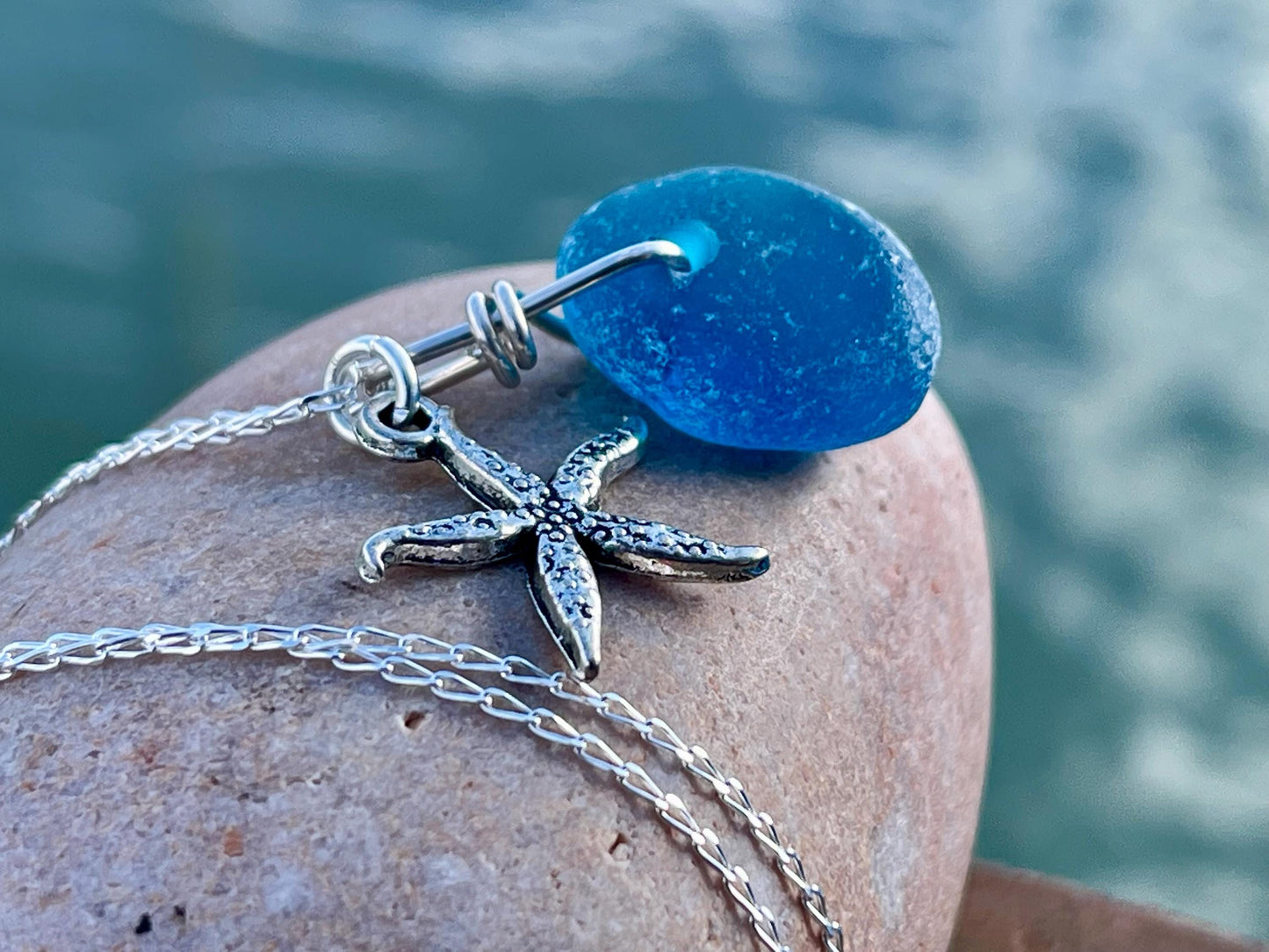 Eco friendly sea glass necklace on a sterling silver chain showcasing a little starfish. Starfish pendant, ethical jewellery. Sea swimming
