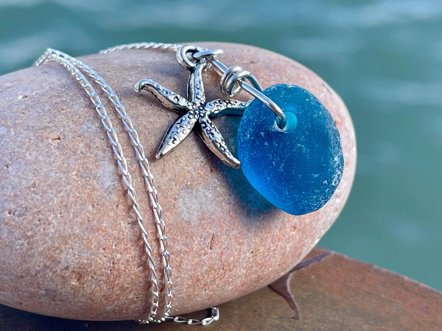 Eco friendly sea glass necklace on a sterling silver chain showcasing a little starfish. Starfish pendant, ethical jewellery. Sea swimming