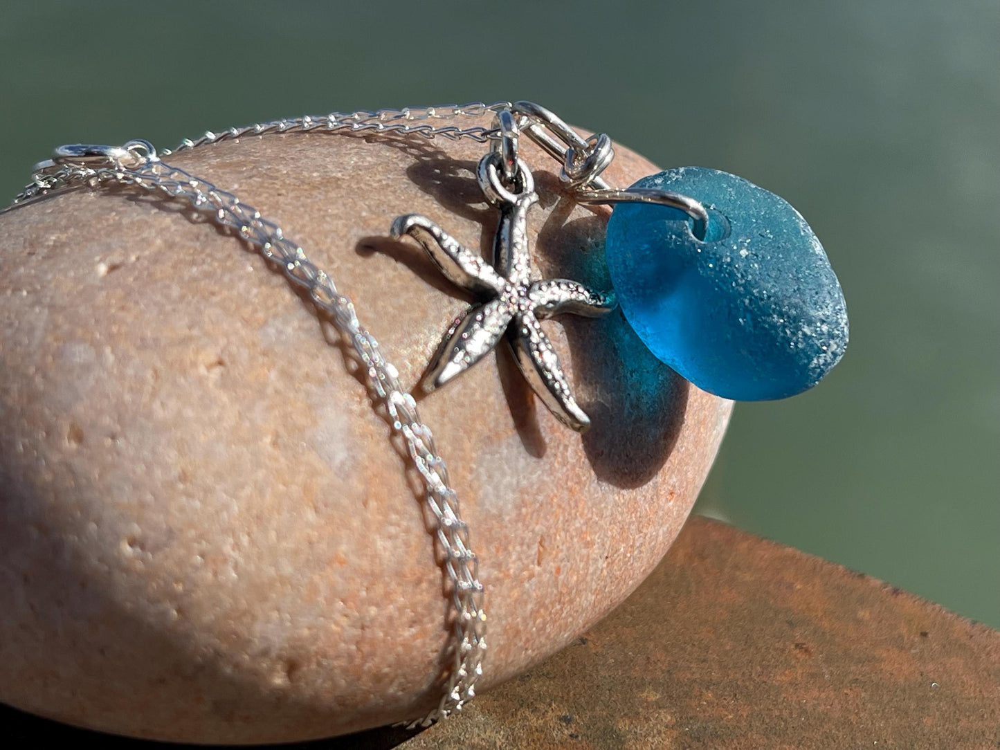 Eco friendly sea glass necklace on a sterling silver chain showcasing a little starfish. Starfish pendant, ethical jewellery. Sea swimming