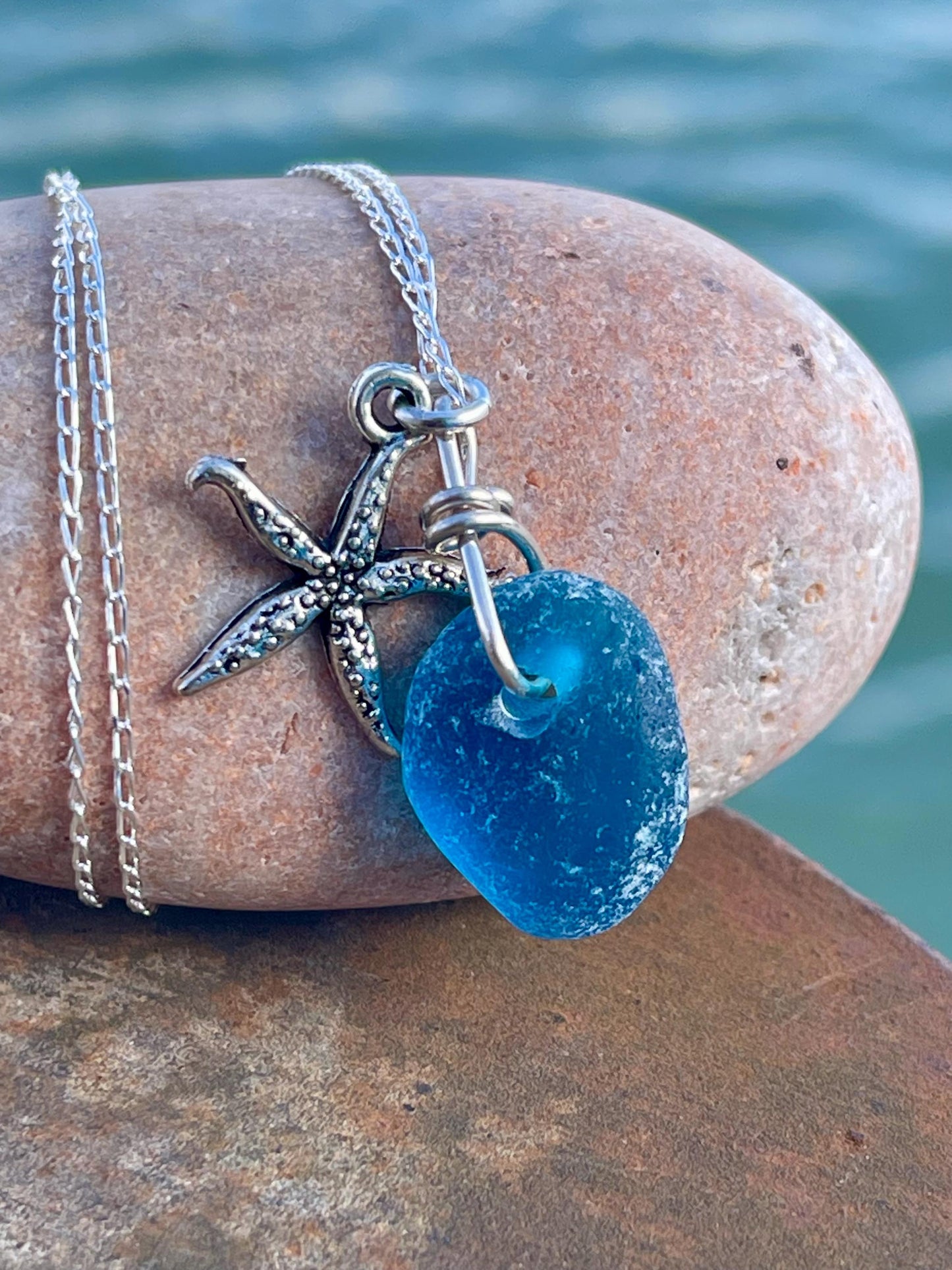 Eco friendly sea glass necklace on a sterling silver chain showcasing a little starfish. Starfish pendant, ethical jewellery. Sea swimming