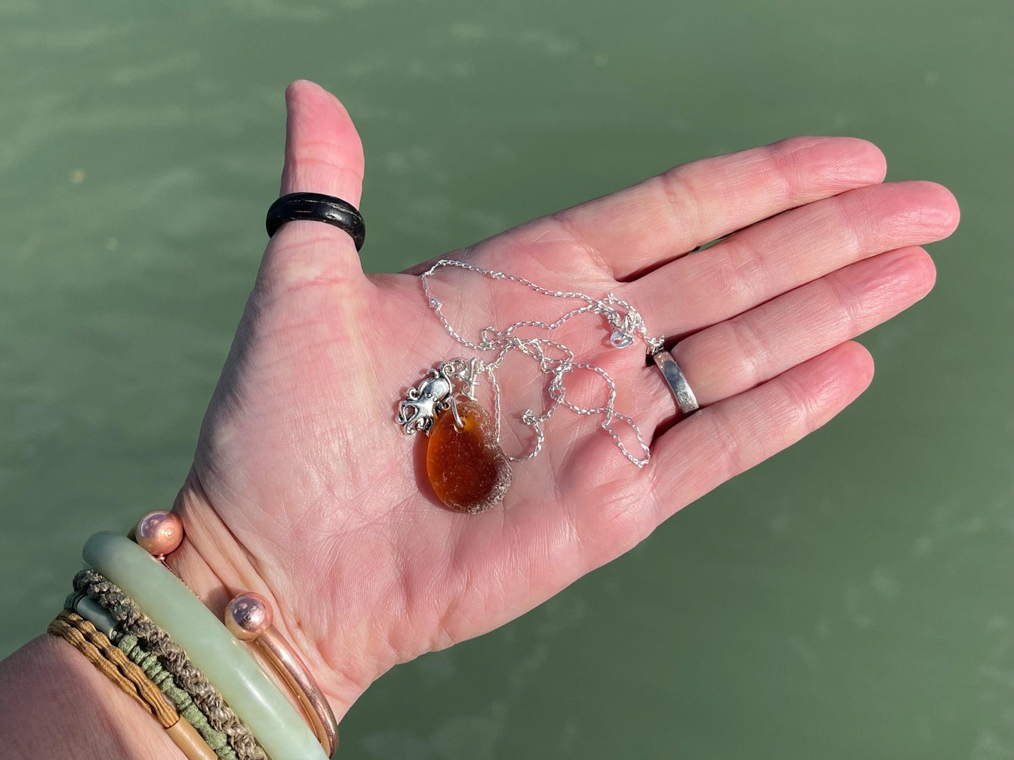 Eco friendly sea glass necklace on a sterling silver chain showcasing a little octopus. Octopus pendant, octopus necklace, ethical jewellery