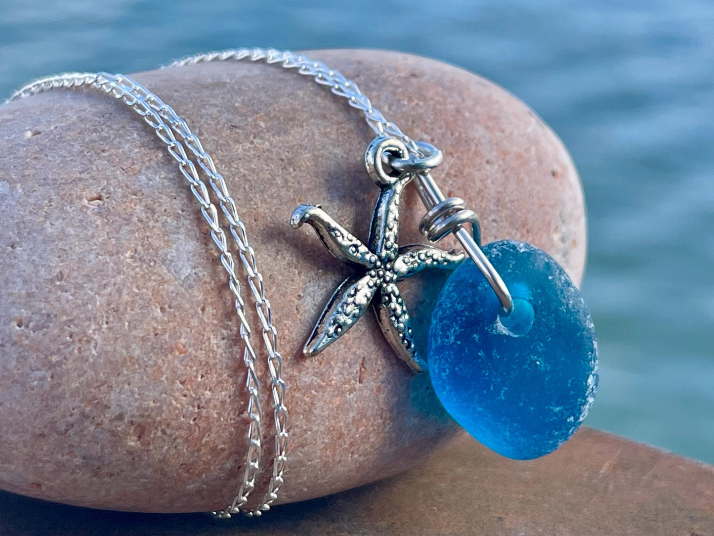 Eco friendly sea glass necklace on a sterling silver chain showcasing a little starfish. Starfish pendant, ethical jewellery. Sea swimming