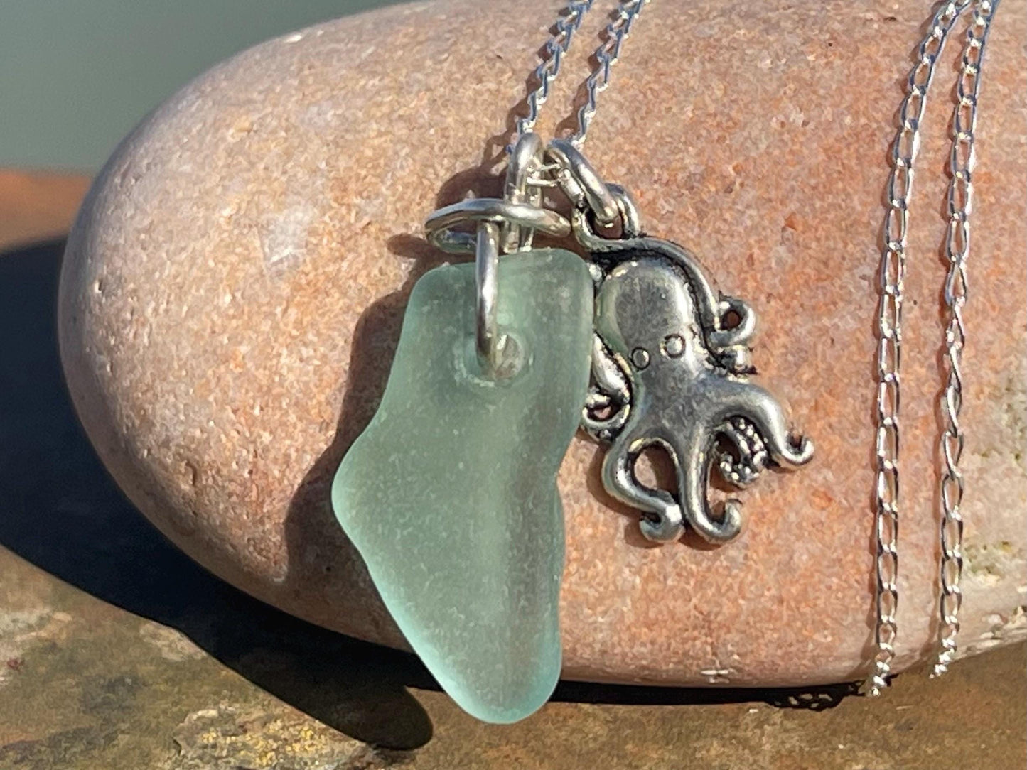 Eco friendly aqua sea glass necklace on a sterling silver chain showcasing a little octopus. Octopus pendant, eco friendly jewellery.