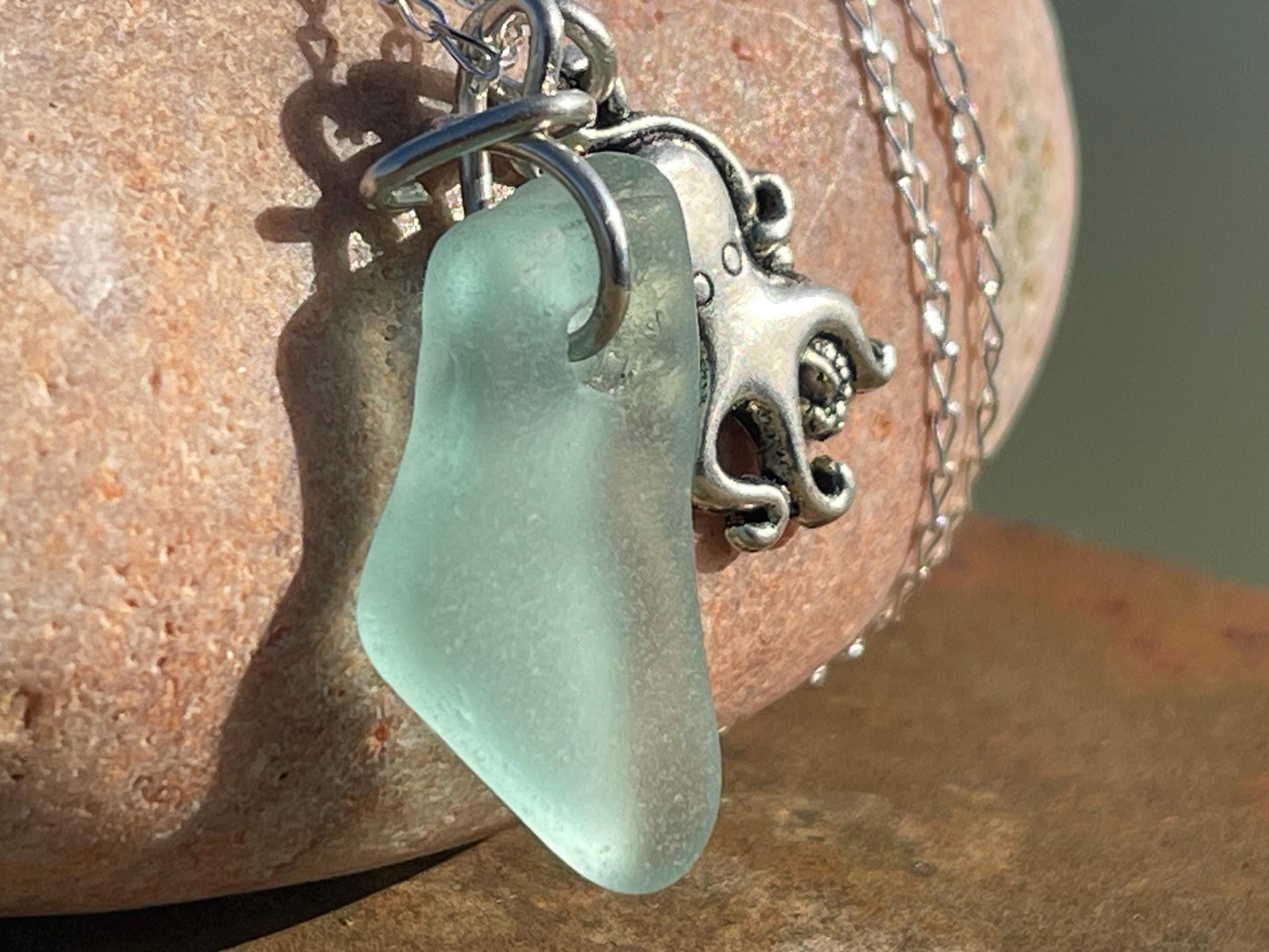 Eco friendly aqua sea glass necklace on a sterling silver chain showcasing a little octopus. Octopus pendant, eco friendly jewellery.
