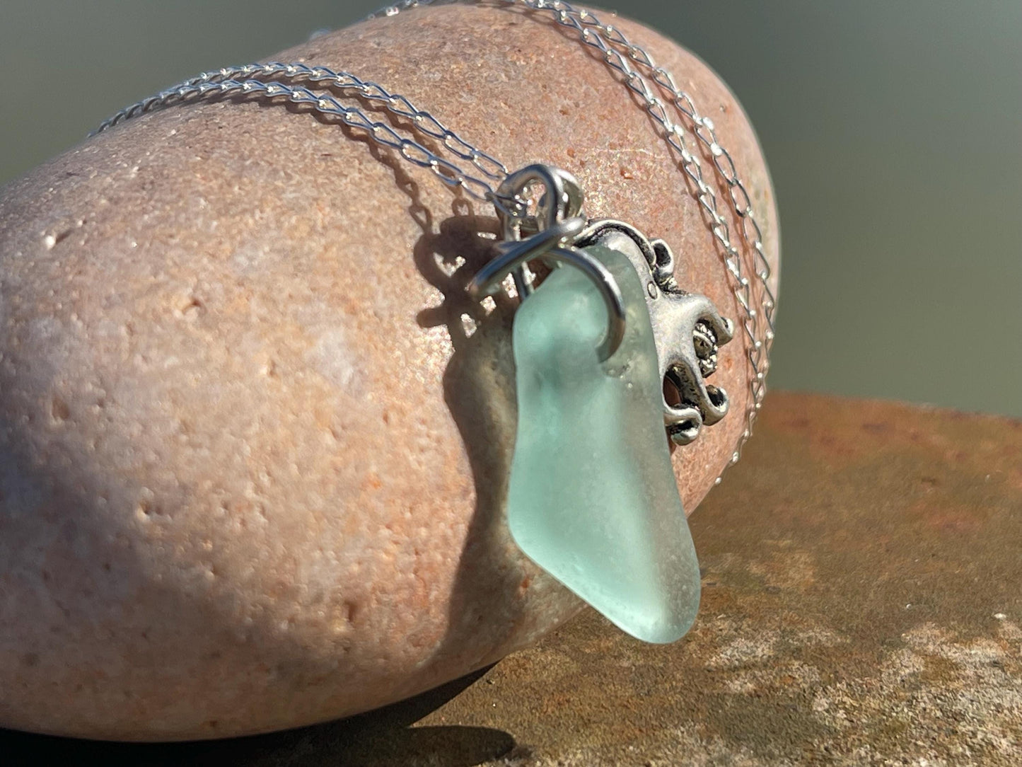Eco friendly aqua sea glass necklace on a sterling silver chain showcasing a little octopus. Octopus pendant, eco friendly jewellery.