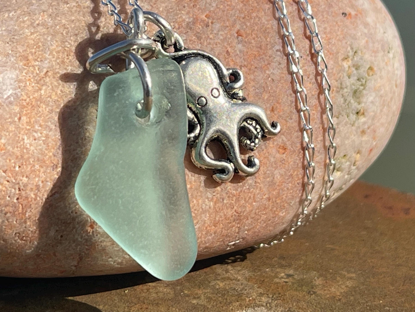 Eco friendly aqua sea glass necklace on a sterling silver chain showcasing a little octopus. Octopus pendant, eco friendly jewellery.