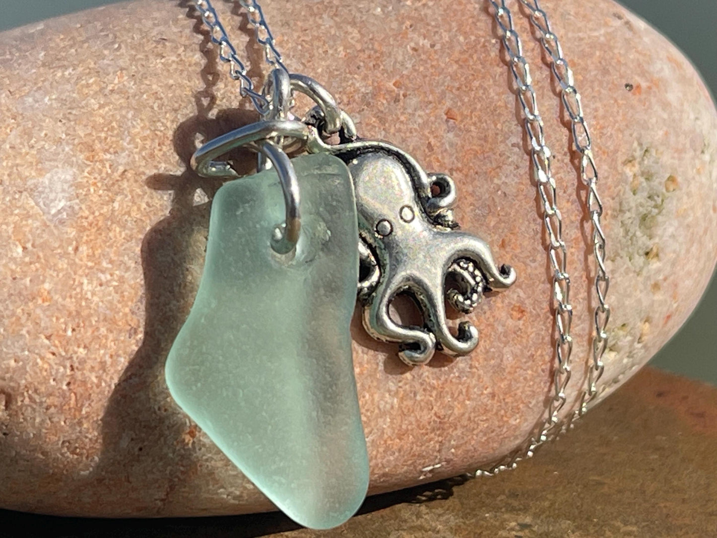 Eco friendly aqua sea glass necklace on a sterling silver chain showcasing a little octopus. Octopus pendant, eco friendly jewellery.