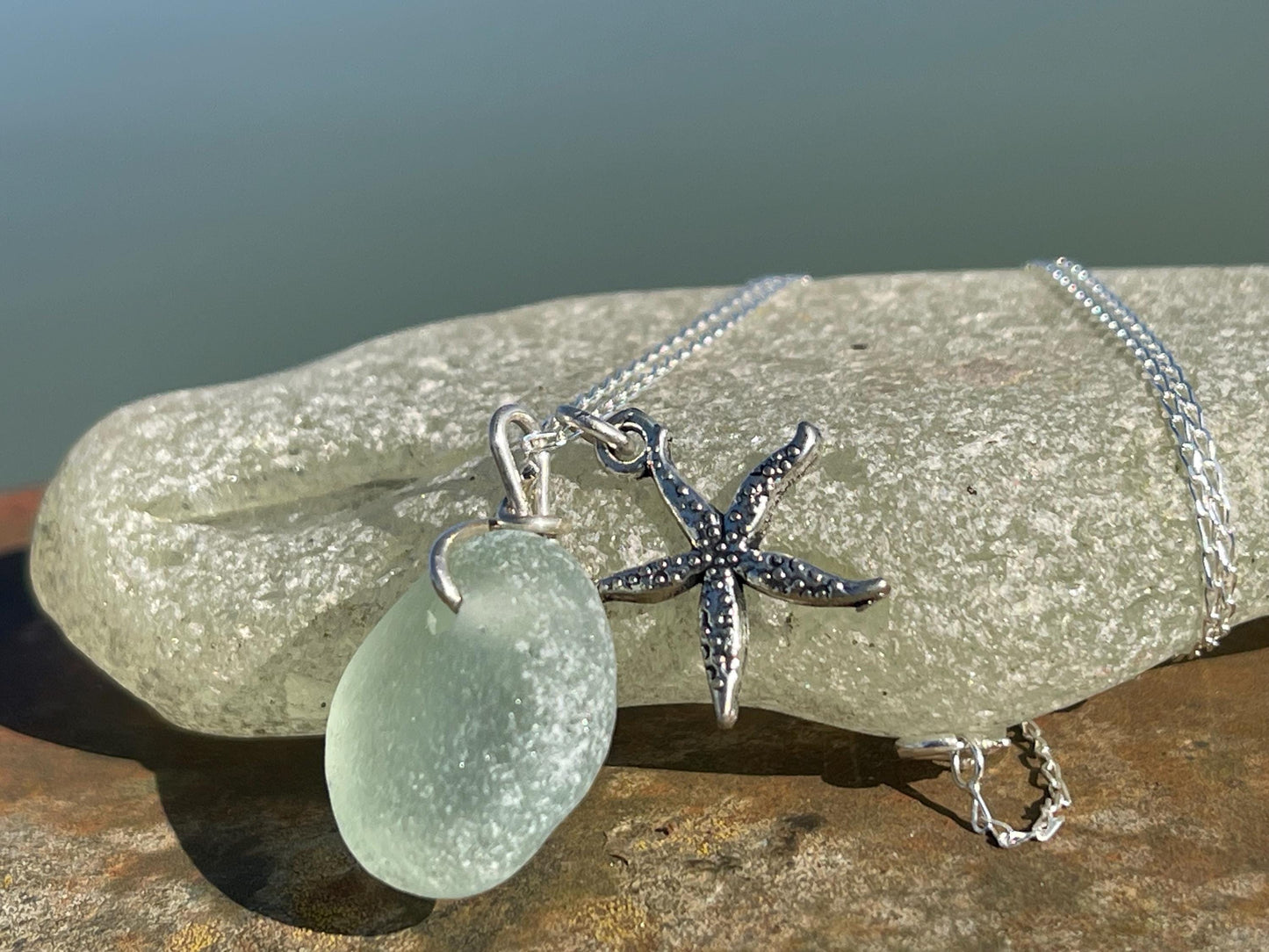 Eco friendly white sea glass necklace on a sterling silver chain showcasing a little starfish. Starfish pendant, eco friendly jewellery.