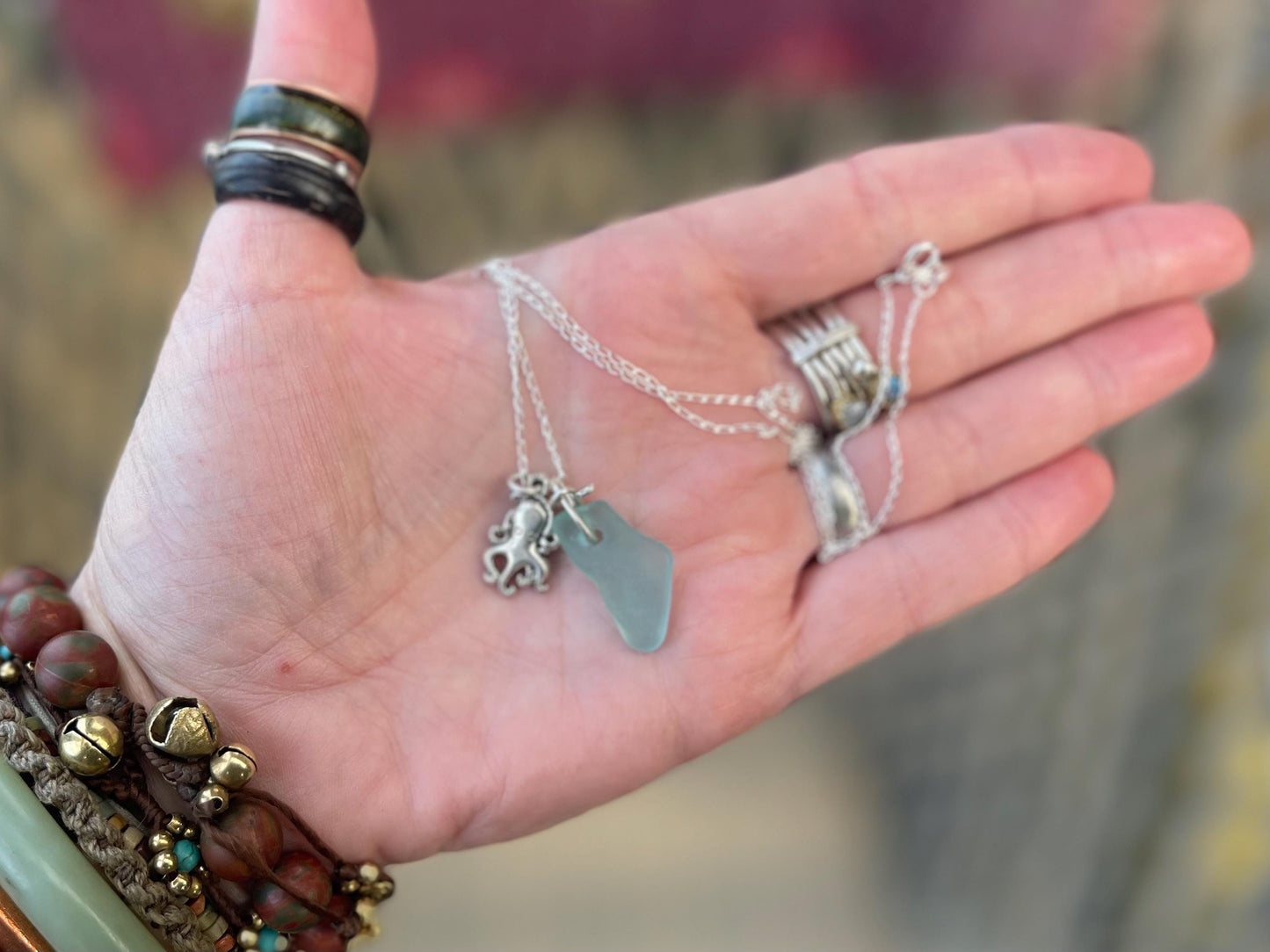 Eco friendly aqua sea glass necklace on a sterling silver chain showcasing a little octopus. Octopus pendant, eco friendly jewellery.