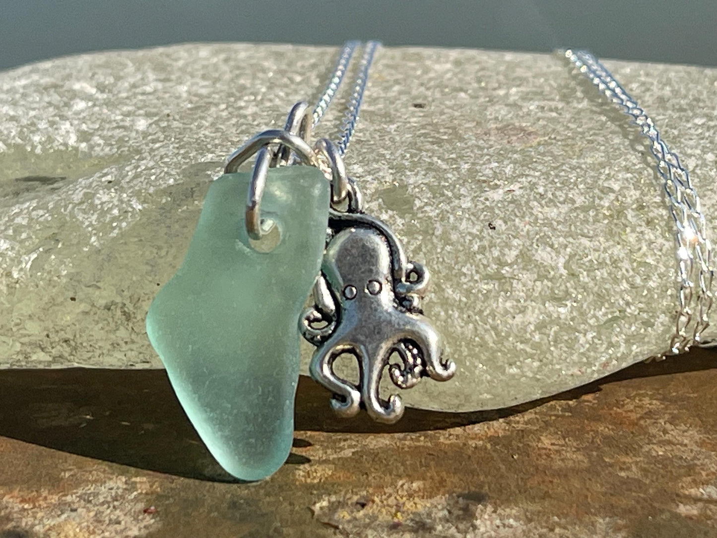 Eco friendly aqua sea glass necklace on a sterling silver chain showcasing a little octopus. Octopus pendant, eco friendly jewellery.
