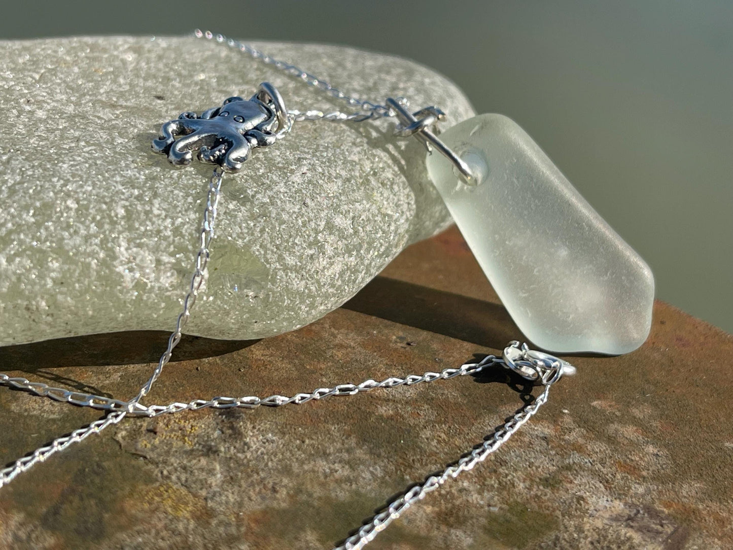 Eco friendly sea glass necklace on a sterling silver chain showcasing a little octopus. Octopus pendant, eco friendly jewellery.