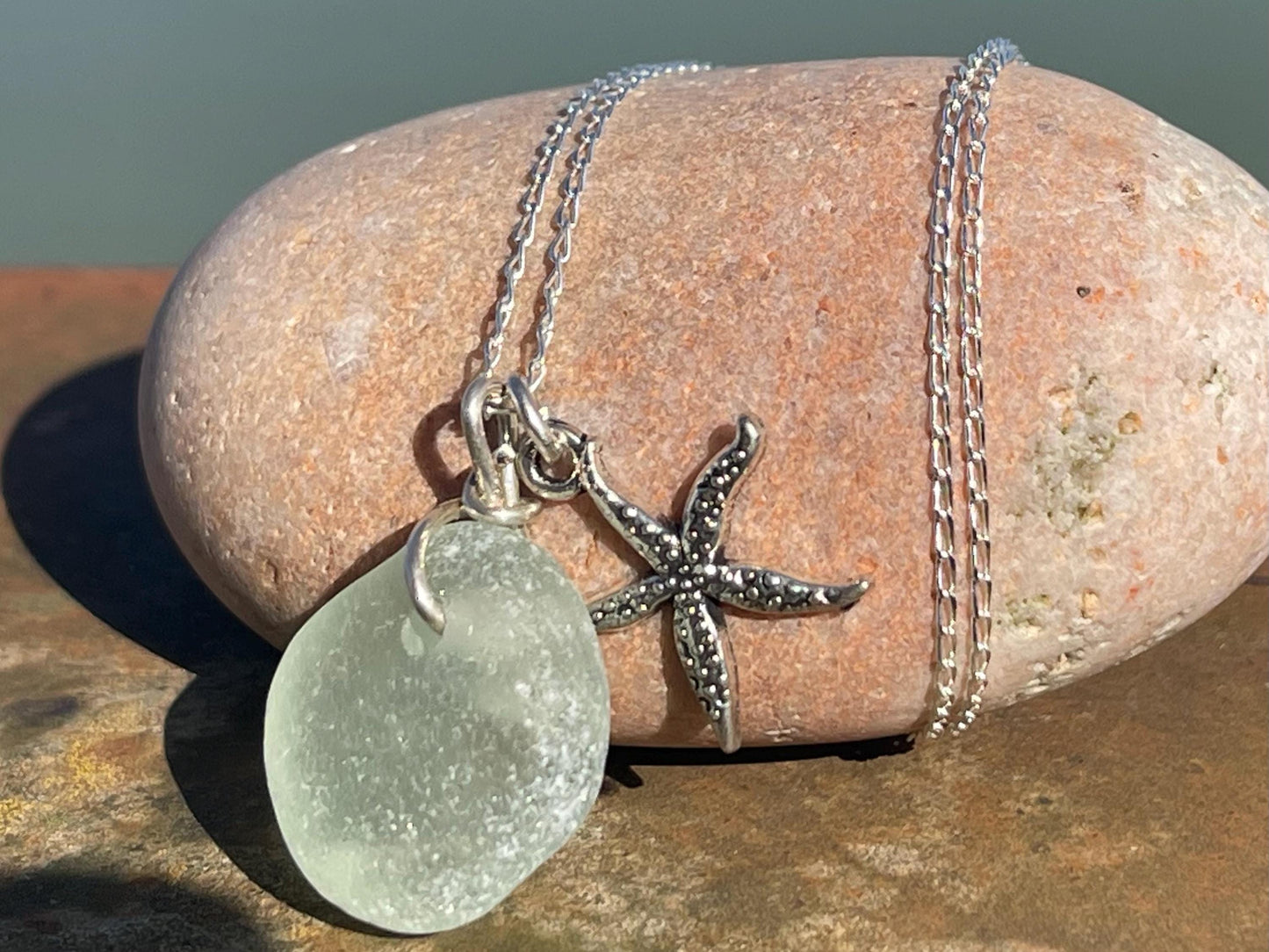 Eco friendly white sea glass necklace on a sterling silver chain showcasing a little starfish. Starfish pendant, eco friendly jewellery.