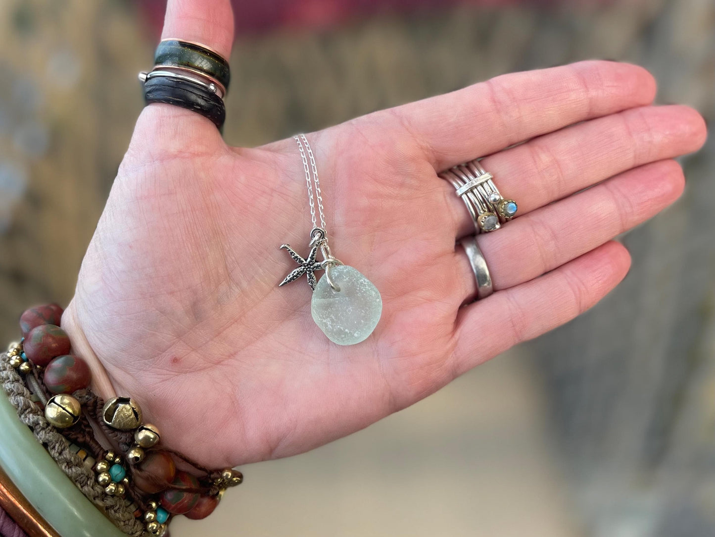 Eco friendly white sea glass necklace on a sterling silver chain showcasing a little starfish. Starfish pendant, eco friendly jewellery.