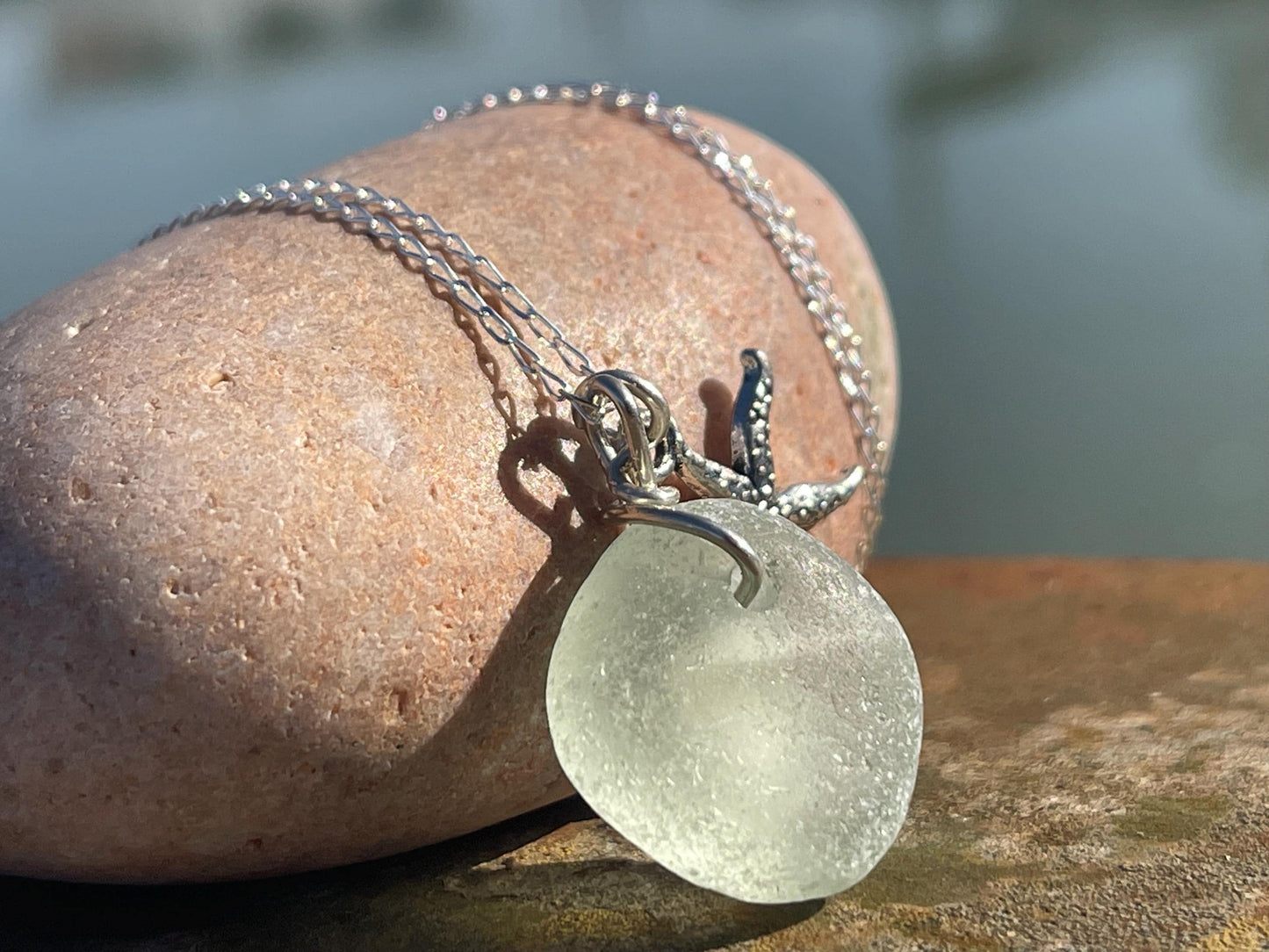 Eco friendly white sea glass necklace on a sterling silver chain showcasing a little starfish. Starfish pendant, eco friendly jewellery.