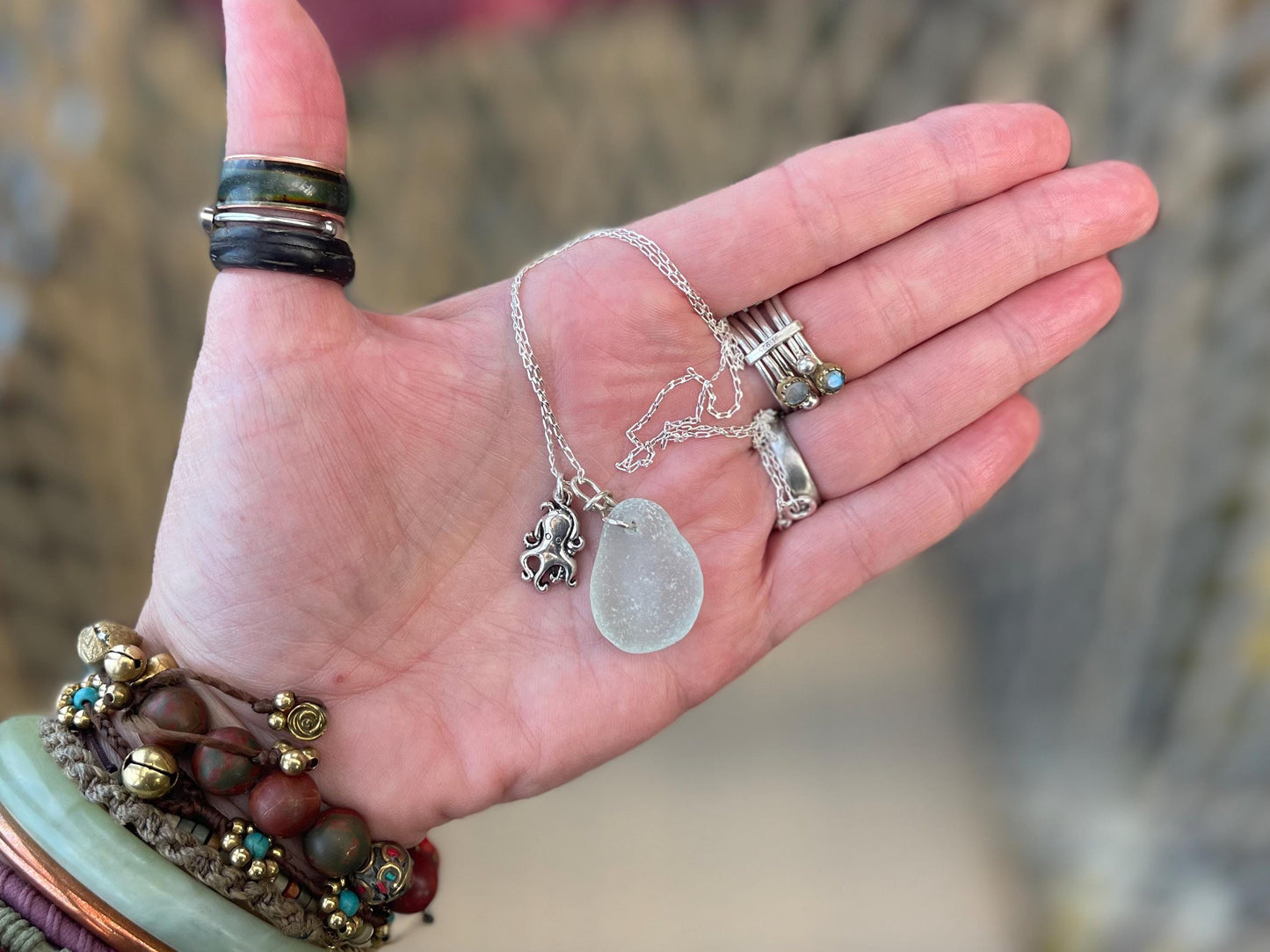 Eco friendly aqua sea glass necklace on a sterling silver chain showcasing a little octopus. Octopus pendant, eco friendly jewellery.