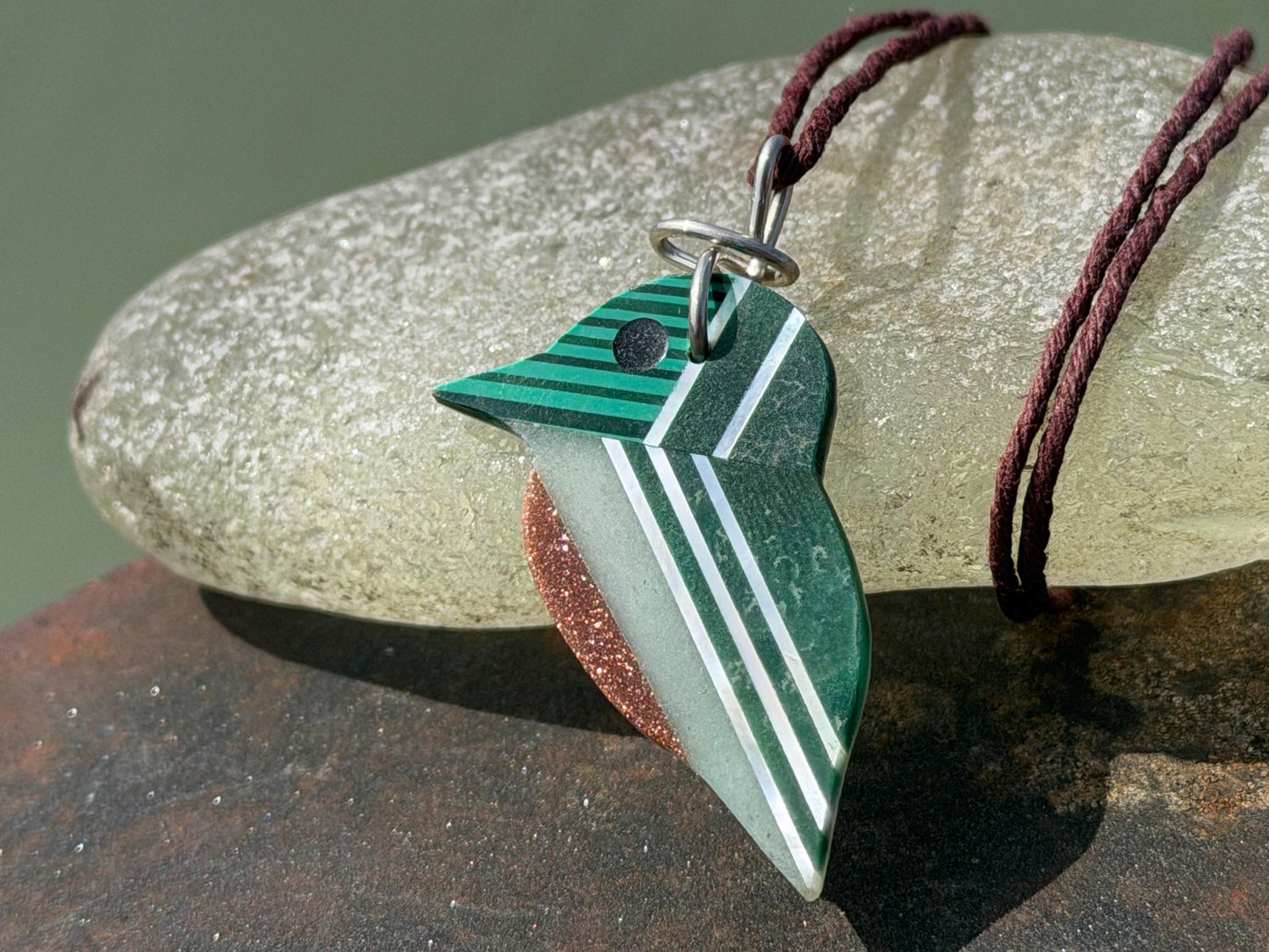 Kingfisher necklace showcasing strips of malachite. Green kingfisher pendant wrapped in recycled sterling silver.