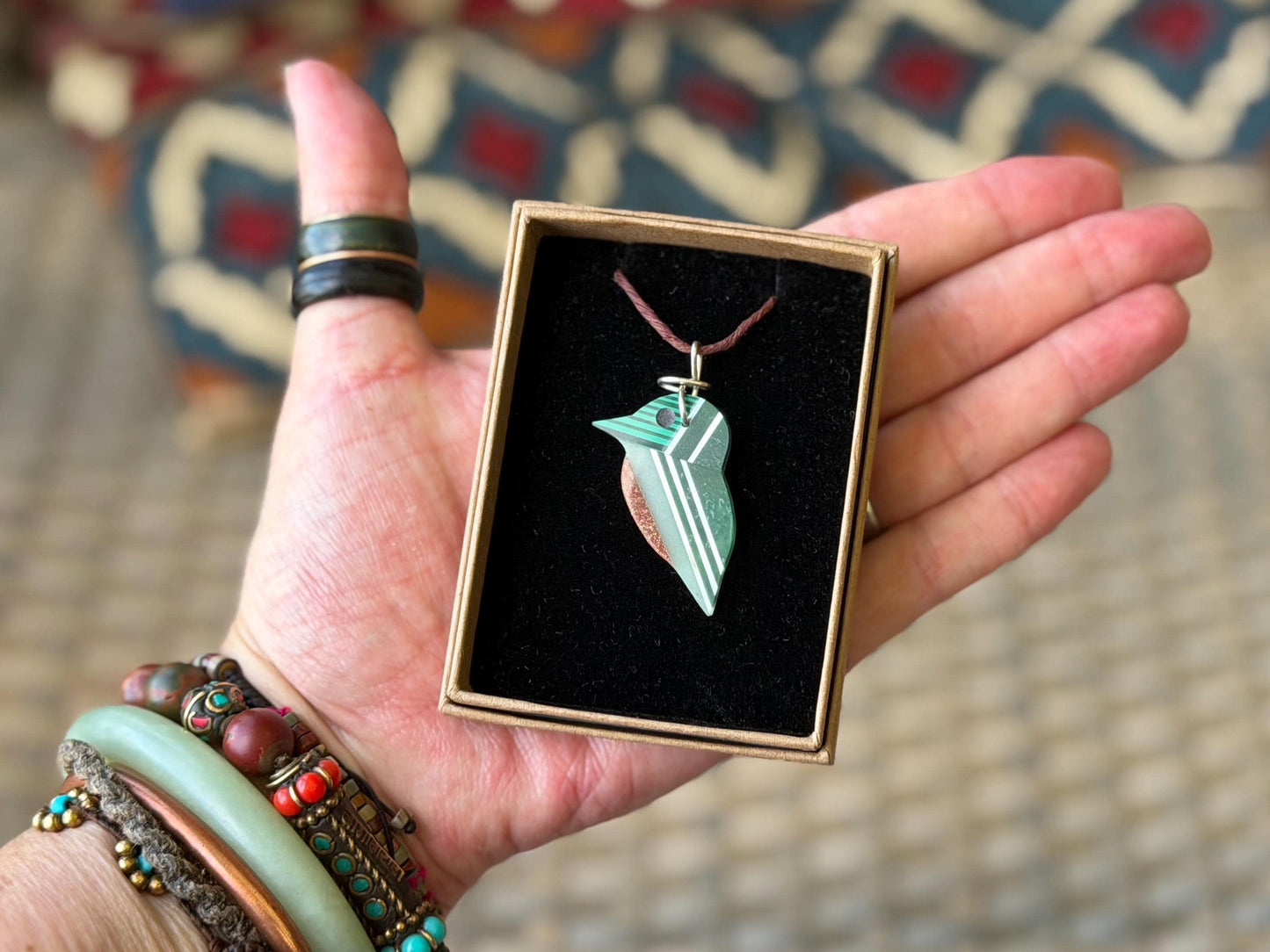 Kingfisher necklace showcasing strips of malachite. Green kingfisher pendant wrapped in recycled sterling silver.