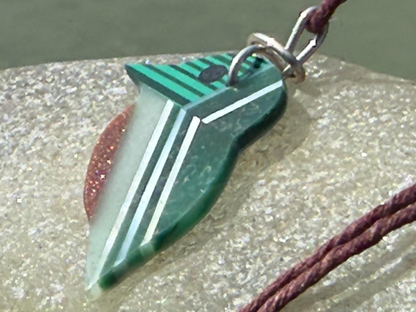 Kingfisher necklace showcasing strips of malachite. Green kingfisher pendant wrapped in recycled sterling silver.