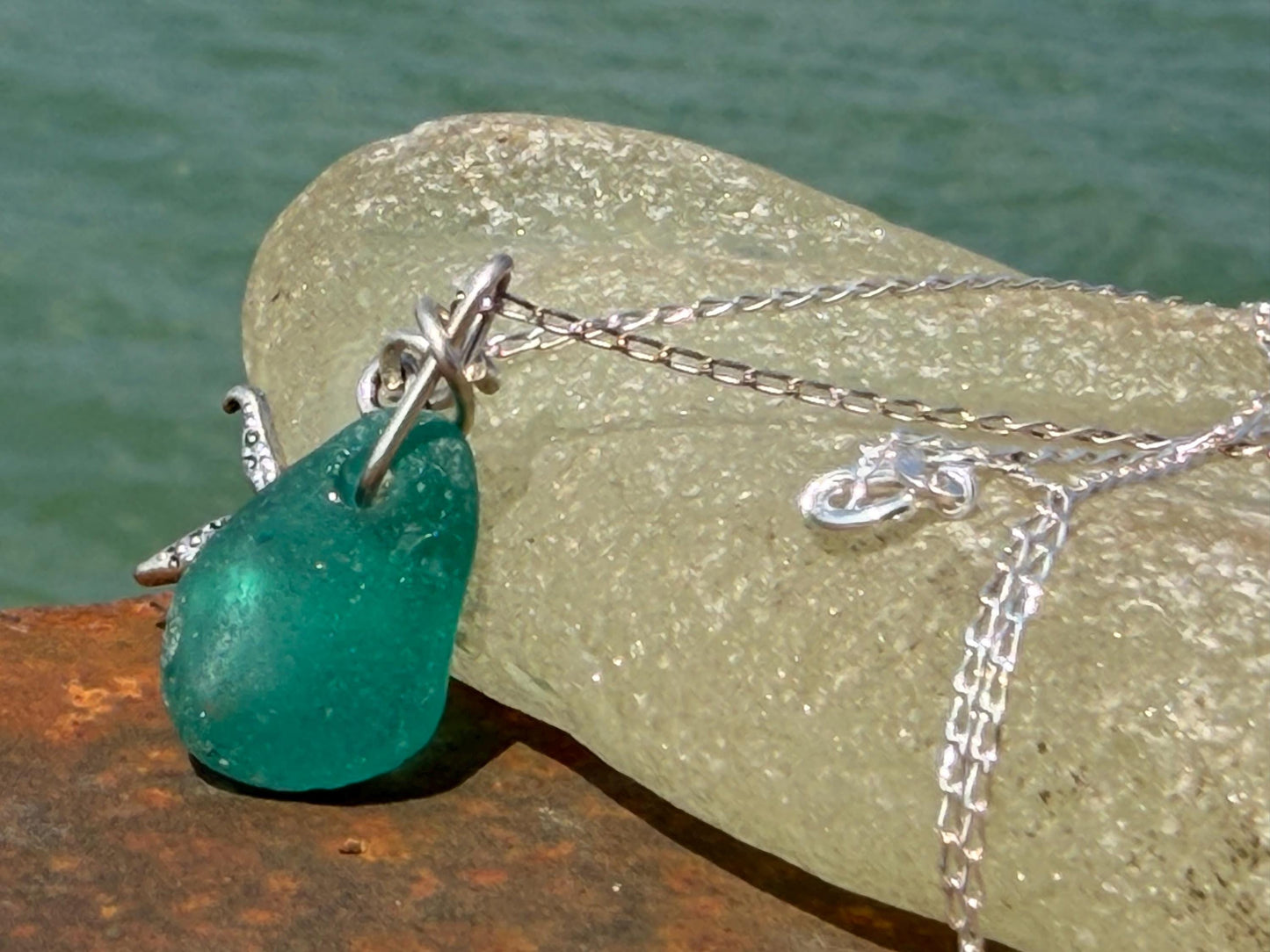 Eco friendly turquoise sea glass necklace on a sterling silver chain showcasing a little starfish. Starfish pendant, eco friendly jewellery.