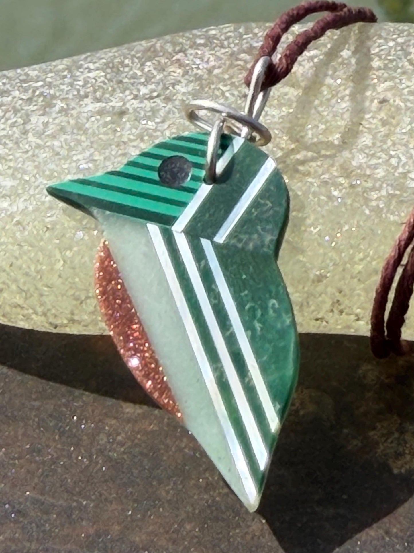 Kingfisher necklace showcasing strips of malachite. Green kingfisher pendant wrapped in recycled sterling silver.