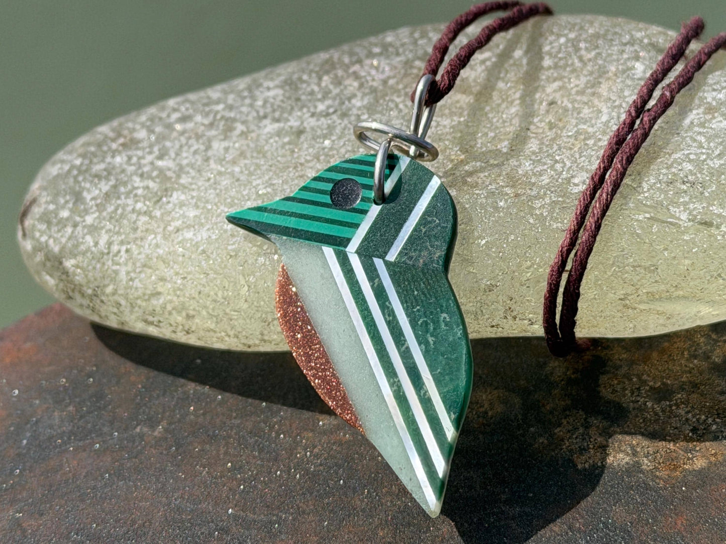 Kingfisher necklace showcasing strips of malachite. Green kingfisher pendant wrapped in recycled sterling silver.