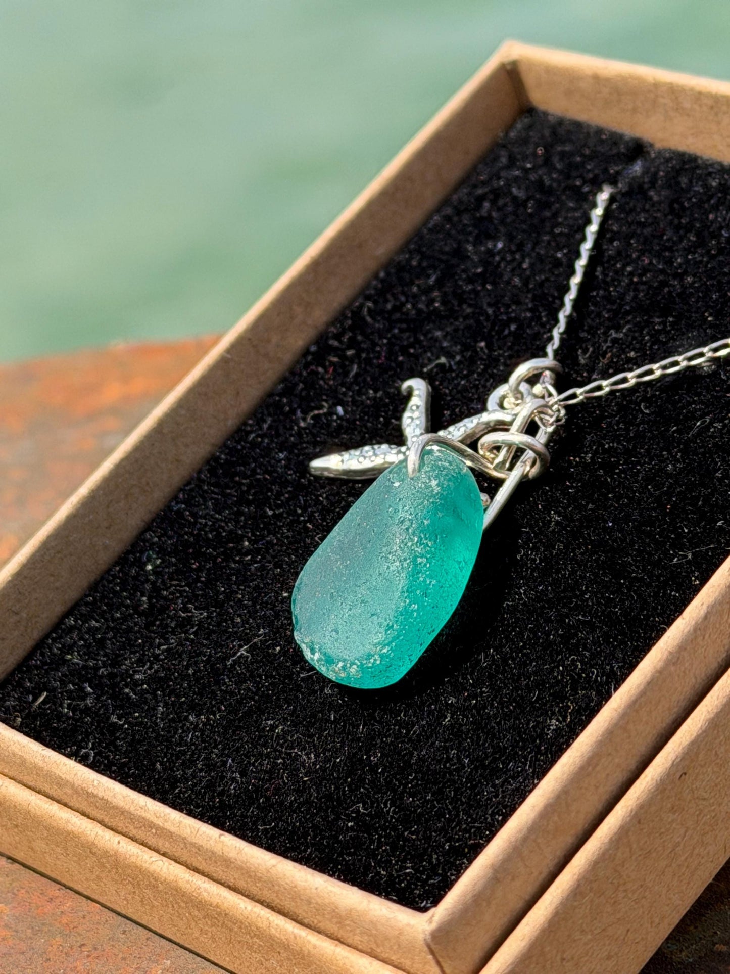 Eco friendly turquoise sea glass necklace on a sterling silver chain showcasing a little starfish. Starfish pendant, eco friendly jewellery.
