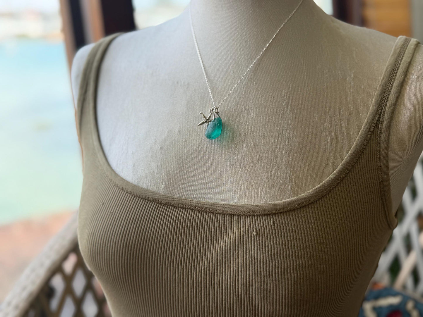 Eco friendly turquoise sea glass necklace on a sterling silver chain showcasing a little starfish. Starfish pendant, eco friendly jewellery.
